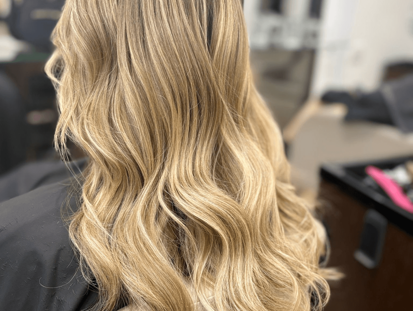 Soft blonde balayage with natural waves created at a Corringham hair salon