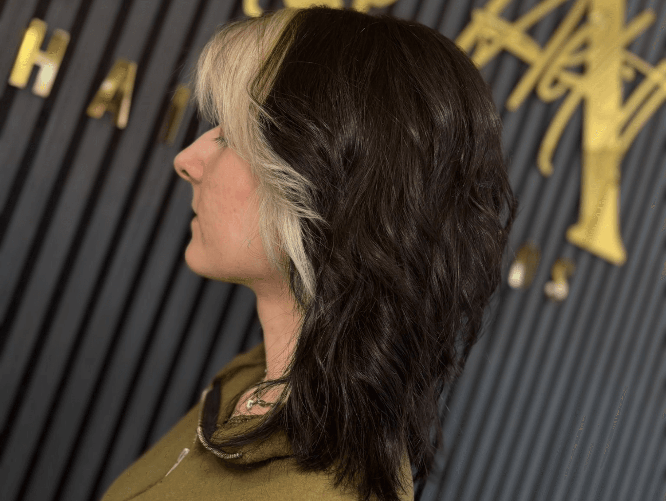 Bold panel hair colour with dark base and blonde section styled at Corringham salon