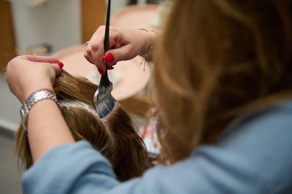 Hairdresser applying semi-permanent root colour at a Corringham-based salon