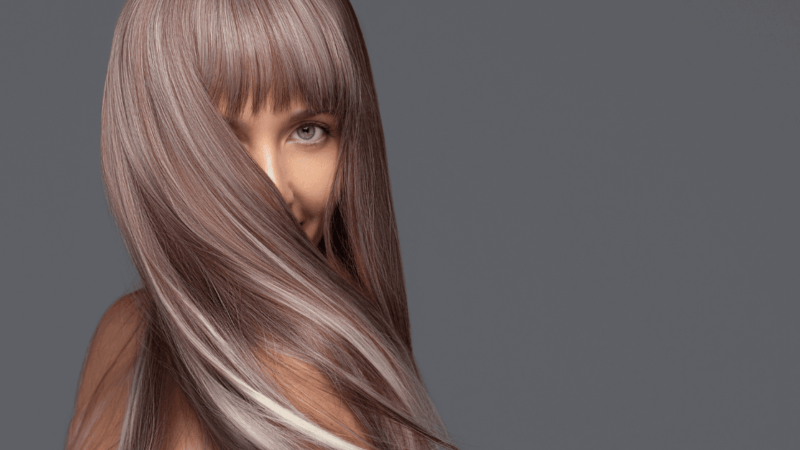 Woman with silky smooth, highlighted hair and fringe, showcasing expert hair colouring at Nicolas Ablitt Hair Studio in Corringham, Essex