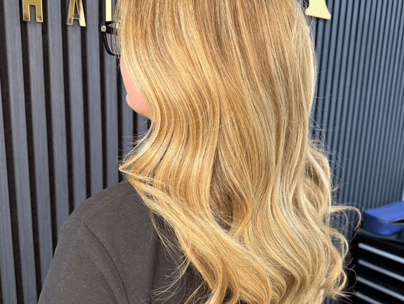 Soft golden blonde hair with loose waves created at Corringham hair salon